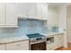 Modern kitchen featuring stainless steel appliances and light blue tile backsplash at 19586 Sw 84Th Pl, Dunnellon, FL 34432