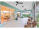 Relaxing screened porch with wicker chairs and view of living room at 19586 Sw 84Th Pl, Dunnellon, FL 34432