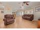 Living room with hardwood floors, brown leather furniture, and a large TV at 20635 Sw 63Rd Pl, Dunnellon, FL 34431