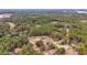 Aerial view of a home in a wooded area with a view of a lake in the distance at 21590 Sw 84Th Loop, Dunnellon, FL 34431