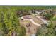 Aerial view of a house on a quiet street surrounded by tall trees at 21590 Sw 84Th Loop, Dunnellon, FL 34431