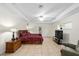 Main bedroom with tiled floors, ceiling fan, and a large TV at 21590 Sw 84Th Loop, Dunnellon, FL 34431