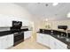 Modern kitchen with white cabinets, granite countertops, and stainless steel appliances at 21590 Sw 84Th Loop, Dunnellon, FL 34431