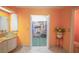 Bathroom with double sinks, orange walls, and large closet at 2831 Sw 139Th St, Ocala, FL 34473