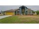 Green house with yellow garage door, landscaping, and a spacious yard at 2831 Sw 139Th St, Ocala, FL 34473