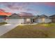 Single-story home with gray siding, attached garage, and landscaped yard at 5050 Sw 91 Pl, Ocala, FL 34476