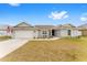 Single-story home with gray siding, attached garage, and landscaped yard at 5050 Sw 91 Pl, Ocala, FL 34476