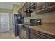 Modern kitchen with dark wood cabinets, granite countertops, and black appliances at 5485 Nw 57Th Ave, Ocala, FL 34482