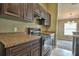 Modern kitchen with dark wood cabinets, granite countertops, and black appliances at 5485 Nw 57Th Ave, Ocala, FL 34482