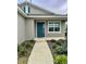 Inviting front entrance with teal door and walkway, enhancing the home's exterior at 7208 Sw 61St Sw Pl, Ocala, FL 34474