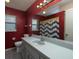 Bathroom features a red wall, a single sink vanity, and a chevron shower curtain at 726 Marion Oaks Ln, Ocala, FL 34473