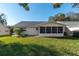 Exterior view of the home with green grass, a patio, and a screened in porch at 8569 Sw 92Nd Ln # F, Ocala, FL 34481