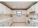 Spacious kitchen featuring bright cabinetry, countertops, a double sink under the window, and tile flooring at 8569 Sw 92Nd Ln # F, Ocala, FL 34481