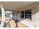 Cozy covered porch highlighting white brick columns, a screen door, and ample natural light creating a welcoming entryway at 8569 Sw 92Nd Ln # F, Ocala, FL 34481