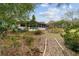 Landscaped backyard with a wooden walkway at 9185 Sw 197Th Cir, Dunnellon, FL 34432