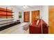 Bedroom with red couch, built-in shelving, and wood flooring at 9185 Sw 197Th Cir, Dunnellon, FL 34432