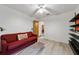 Bedroom with red couch, built in shelving and wood flooring at 9185 Sw 197Th Cir, Dunnellon, FL 34432