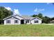 Finished new construction home featuring gray stucco, stone accents, shutters, and a landscaped yard at 12295 Sw 90Th Pl, Dunnellon, FL 34432