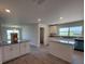 Open kitchen with white cabinets, granite countertops, island, and a view of the dining area at 12295 Sw 90Th Pl, Dunnellon, FL 34432