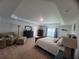 Spacious main bedroom with tray ceiling, neutral decor, a seating area, and plush carpeting at 12295 Sw 90Th Pl, Dunnellon, FL 34432