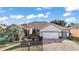 Inviting single-story home with manicured landscaping, paver driveway, and an attached two-car garage at 13077 Se 86 Ct, Summerfield, FL 34491
