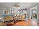 Bright living room with hardwood floors, a sofa, and decorative mirrors at 13077 Se 86 Ct, Summerfield, FL 34491