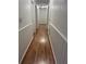 Long hallway with wood-look laminate flooring and white wainscoting at 13410 Sw 3Rd Ct, Ocala, FL 34473