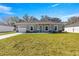 New single story home with gray exterior, attached garage, and well-maintained landscaping at 15148 Se 61St Ct, Summerfield, FL 34491