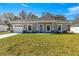 Newly built one-story house featuring gray siding, attached garage, and a spacious lawn at 15148 Se 61St Ct, Summerfield, FL 34491