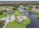 Aerial view of community pool, tennis court, and lake at 21202 Sandalwood Dr # 21-202, Wildwood, FL 34785