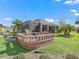 Landscaped backyard with brick patio and screened enclosure at 3416 Eisenhower Way, The Villages, FL 32163