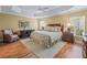 Spacious Primary bedroom with wood floors and ceiling fan at 3416 Eisenhower Way, The Villages, FL 32163