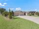 Tan house with three car garage and nicely landscaped lawn at 3416 Eisenhower Way, The Villages, FL 32163