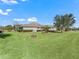 Back exterior view of home showcasing manicured lawn and landscaping at 3416 Eisenhower Way, The Villages, FL 32163