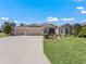 Beautiful home exterior with three-car garage and manicured lawn at 3416 Eisenhower Way, The Villages, FL 32163