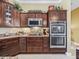 Modern kitchen with double ovens, granite countertops, and wood cabinetry at 3416 Eisenhower Way, The Villages, FL 32163