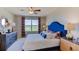 Spacious bedroom with king-size bed, blue headboard, and large window at 348 Hickory Course Trl, Ocala, FL 34472