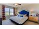 Spacious bedroom with king-size bed, blue headboard, and large window at 348 Hickory Course Trl, Ocala, FL 34472