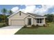 Single-story home with a two-car garage and landscaped front yard at 354 Hickory Course Trl, Ocala, FL 34472