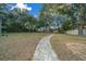 Expansive backyard with a stone paver walkway leading to two storage sheds at 6009 Sw 107Th St, Ocala, FL 34476