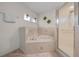 Bathroom showcasing a soaking tub with tile surround and glass shower enclosure at 6009 Sw 107Th St, Ocala, FL 34476