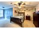 Cozy bedroom featuring a ceiling fan, a wooden bed frame and sneaker art on the walls at 6701 Se 99Th Pl, Belleview, FL 34420