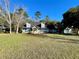 Exterior shot of blue home with manicured lawn, black roof and separate garage at 6701 Se 99Th Pl, Belleview, FL 34420