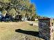 Spacious front yard with mature trees, driveway, and stone-clad mailbox, leading to a home with a detached garage at 6701 Se 99Th Pl, Belleview, FL 34420