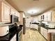 Bright kitchen featuring stainless steel appliances, black countertops, and wood-look flooring at 6701 Se 99Th Pl, Belleview, FL 34420