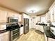 Well-lit kitchen featuring stainless steel appliances, black countertops, and wood-look flooring at 6701 Se 99Th Pl, Belleview, FL 34420