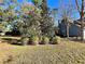 Landscaped shrubbery sits in the yard near a grey house with a brick chimney at 6701 Se 99Th Pl, Belleview, FL 34420