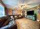 Cozy living room with plush leather seating, modern entertainment center and brick accent wall at 6701 Se 99Th Pl, Belleview, FL 34420