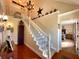 Bright foyer staircase with carpeted steps and decorative accents leading to the second floor and a glimpse into the Primary bedroom at 6701 Se 99Th Pl, Belleview, FL 34420