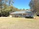 Tan house with gray roof, 2-car garage, and large yard at 73 Fir Dr, Ocala, FL 34472